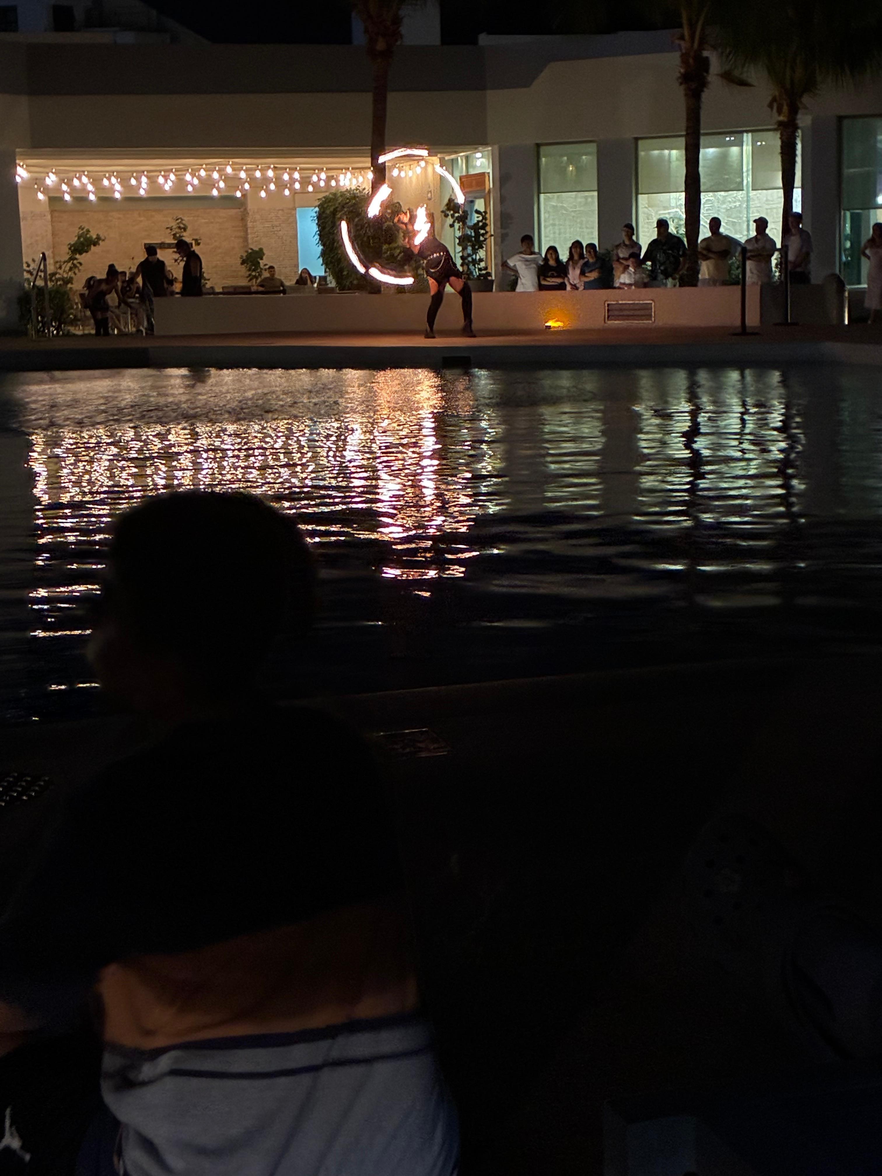 Fire juggling show by the pool outside 