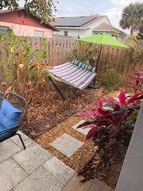 Fenced back yard wraps around the side of house