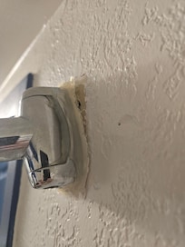 The curtain rod is falling off the wall, leading to the curtain covering the floor of the shower when in use.