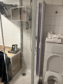 L'entrée de la douche se trouve contre le toilette