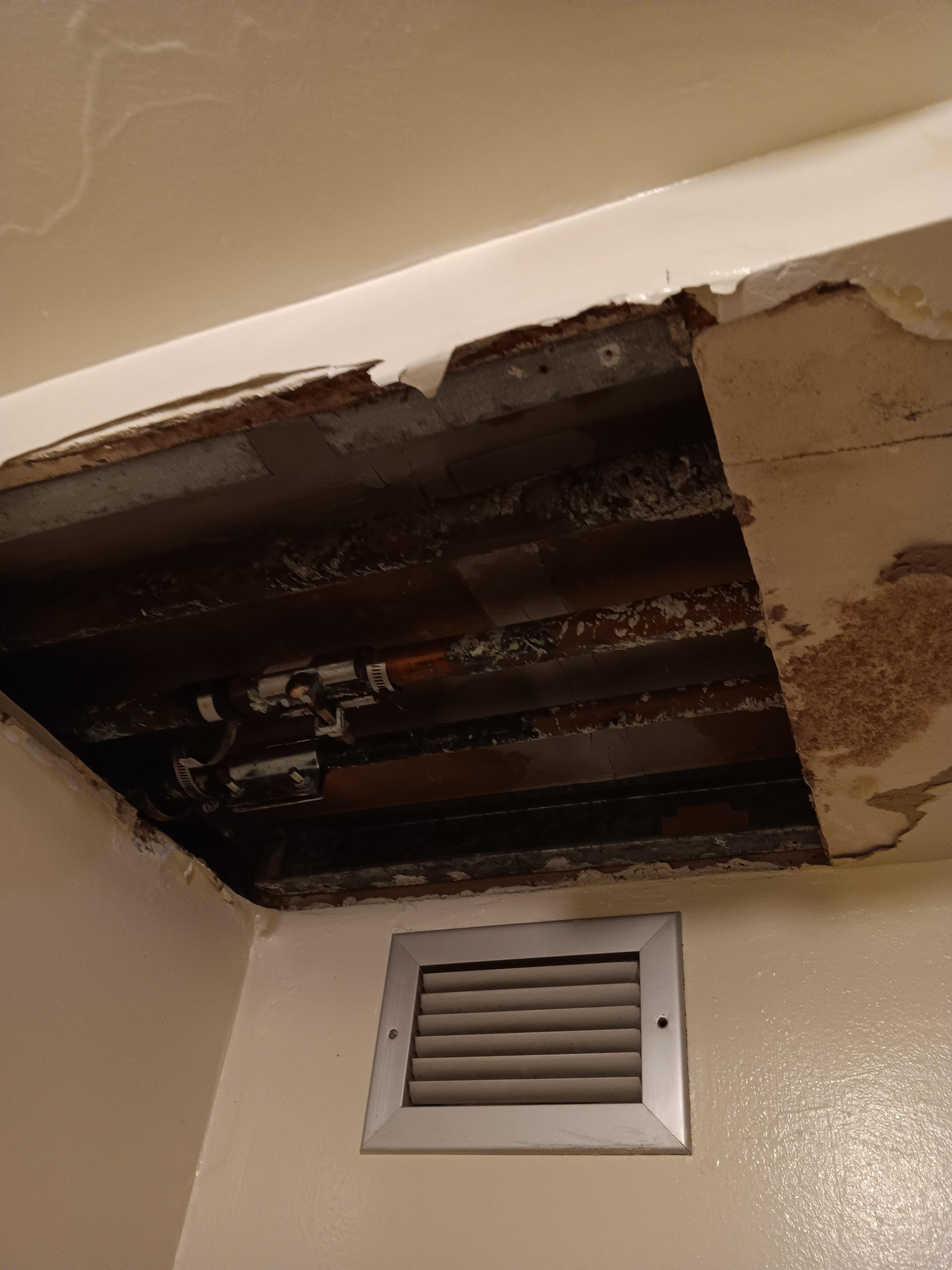 hole in ceiling and exposed pipes