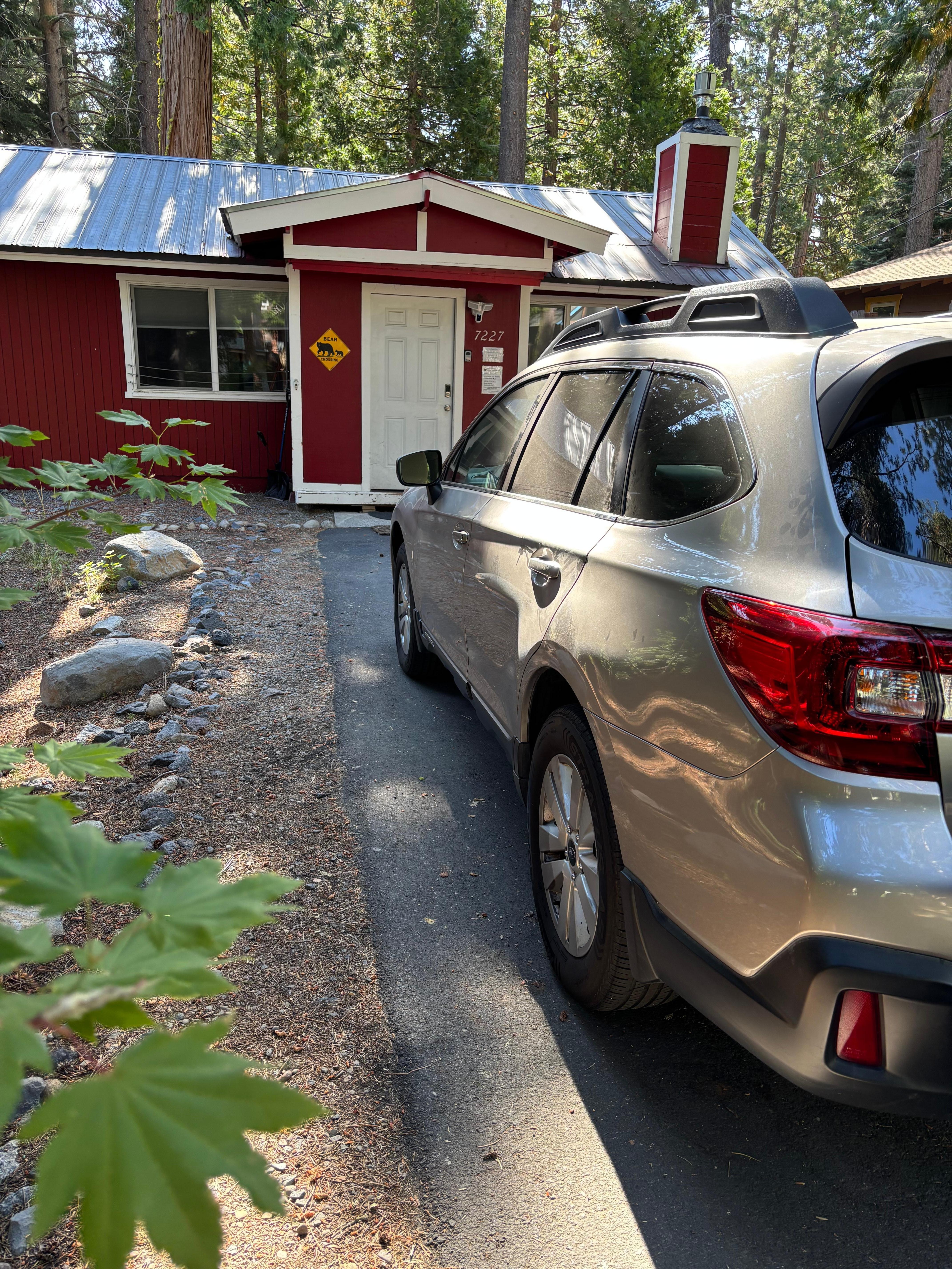 The cabin is nestled amongst tall trees. 