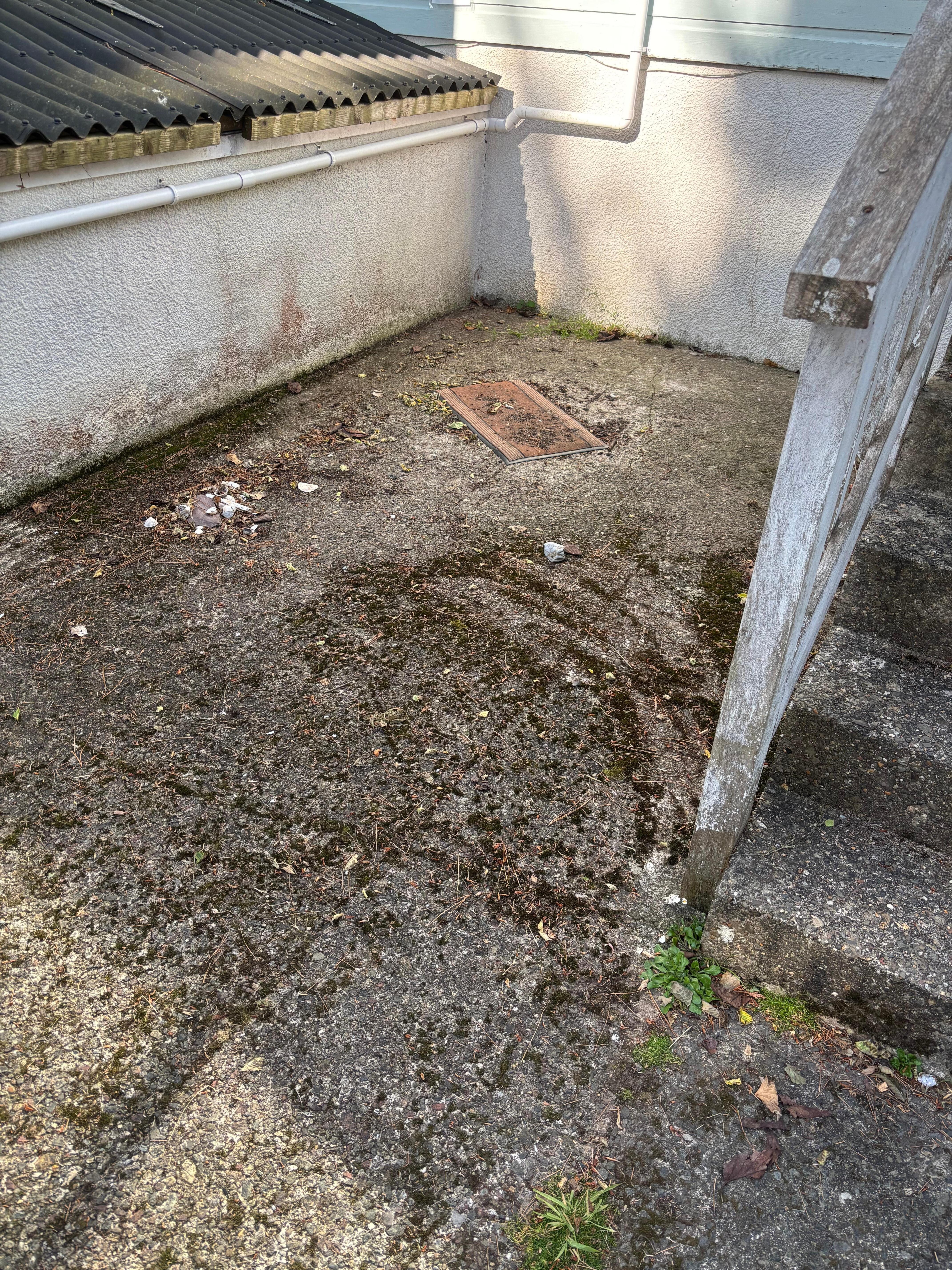 Outdoor patio with discarded mat. The storage boxes contained junk.