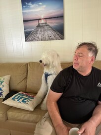 This is my friend sitting in the living room with my dog that we brought with us