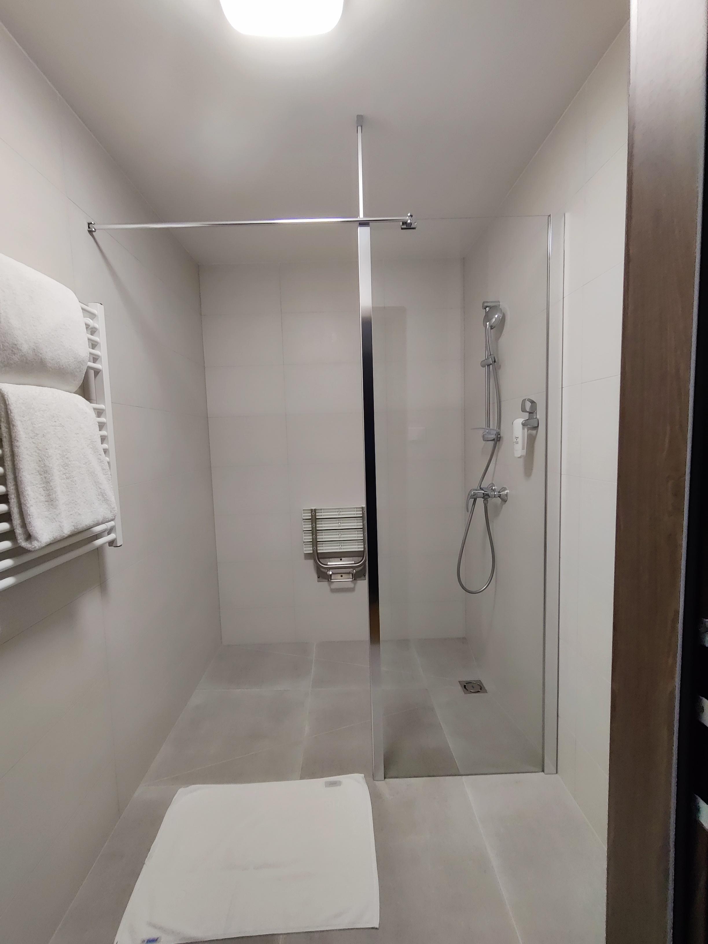 Standalone shower. Accessible set is too far from controls of the shower. 