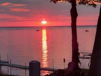 Sunset over the lake with multiple boats fishing out there.