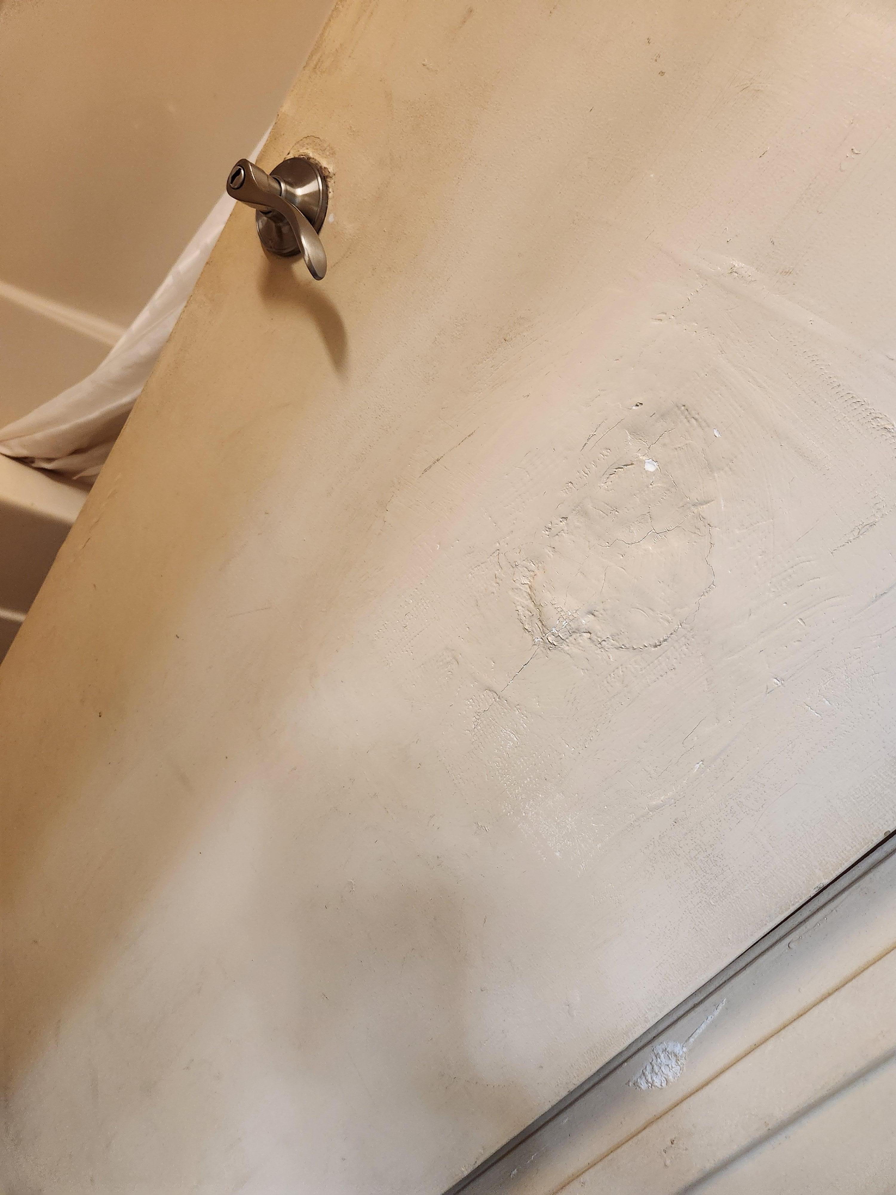 Poorly patched hole on bathroom door