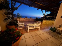 The large patio has a sitting area, lounge chairs, a dining table, outdoor showers, and breathtaking views (although there are electrical lines that obstruct some of it)