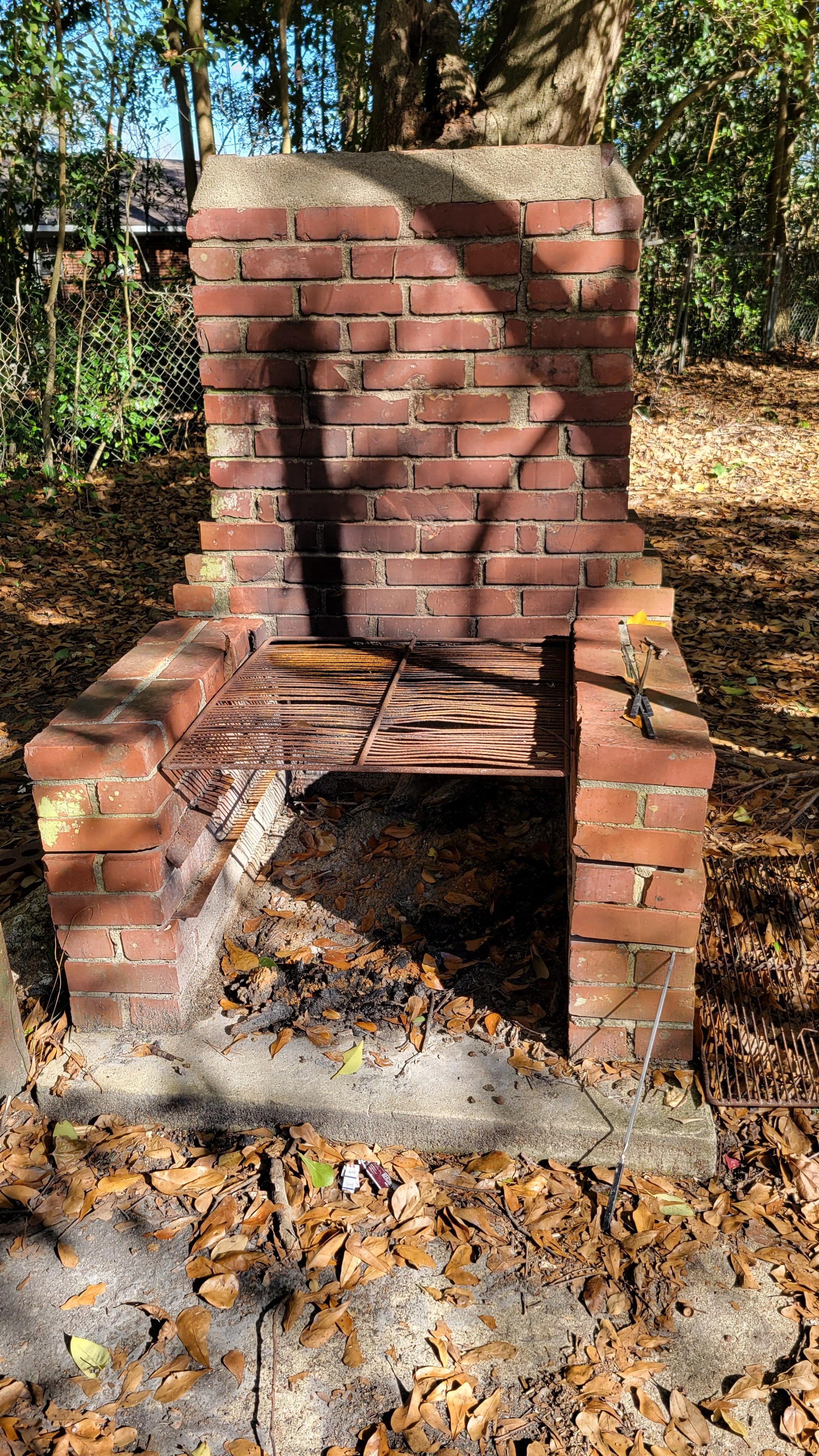 Severely rusted fire grill grates and trash on ground