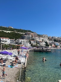Badstrand med vackert klart vatten nedanför hotellet.