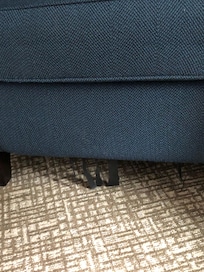 Material hanging from the bottom of the upholstered chair.