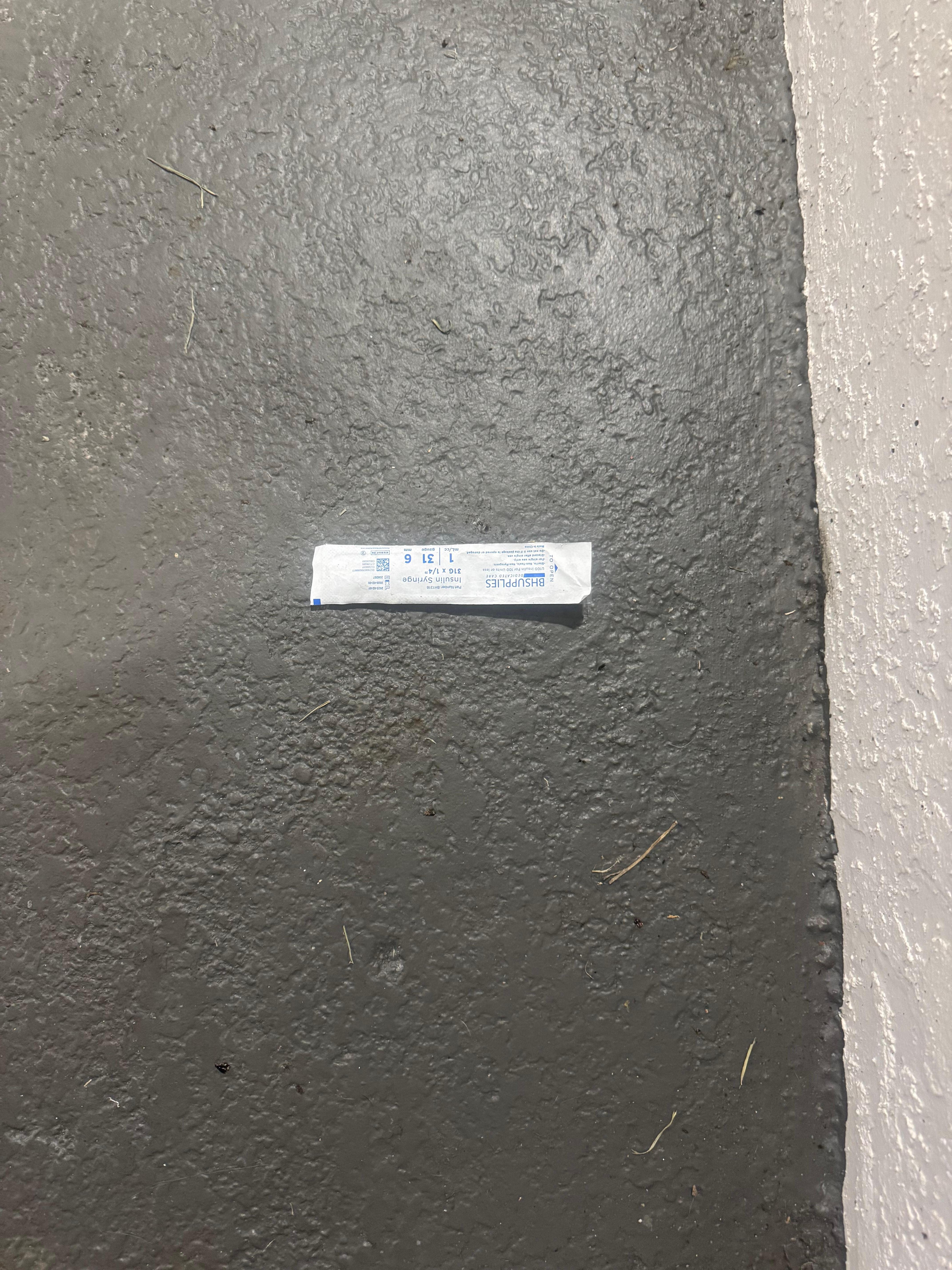 Needle wrapper directly outside hotel room door 
