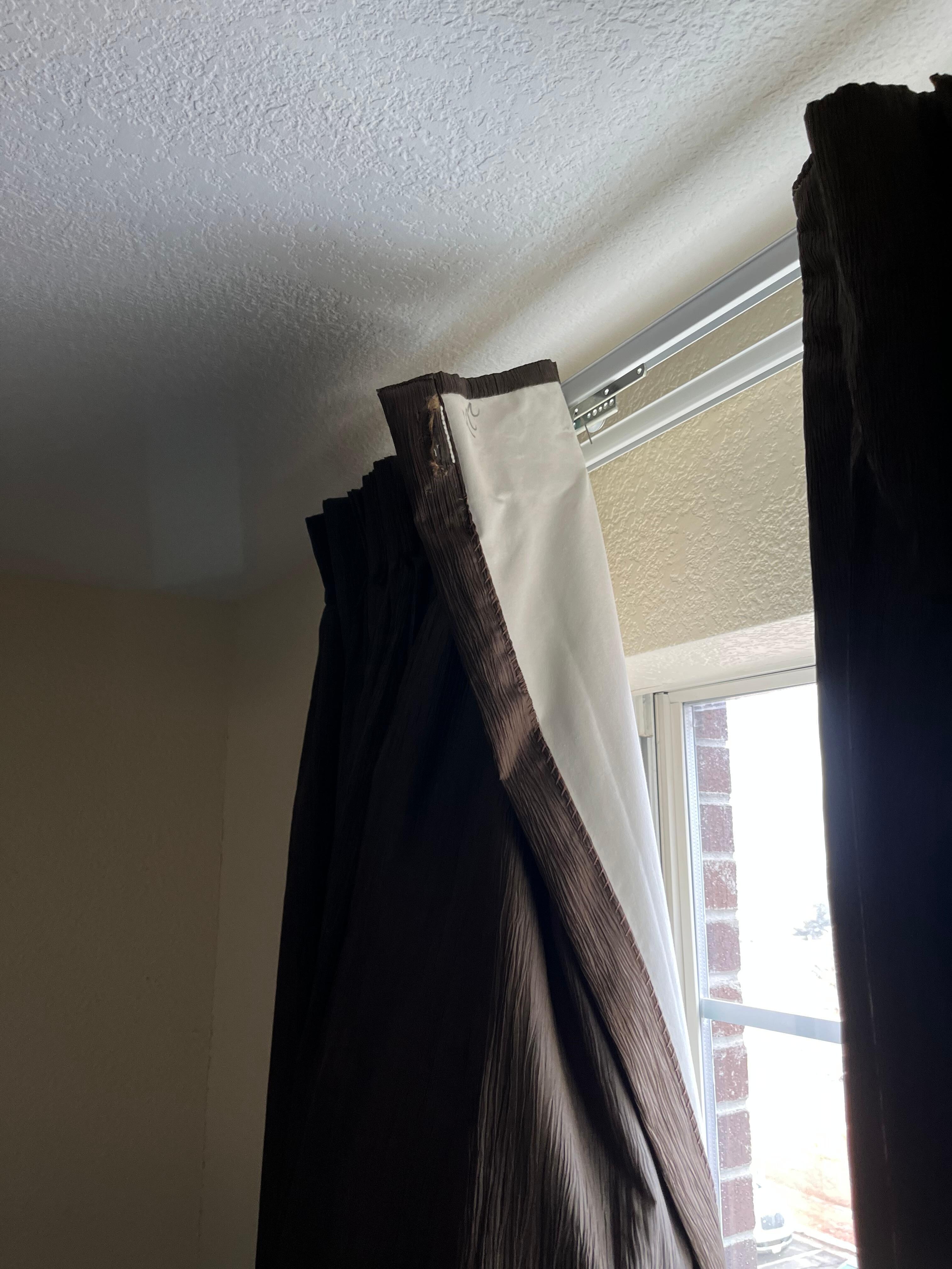 curtains are hanging down without the drapery hooks to hold them up