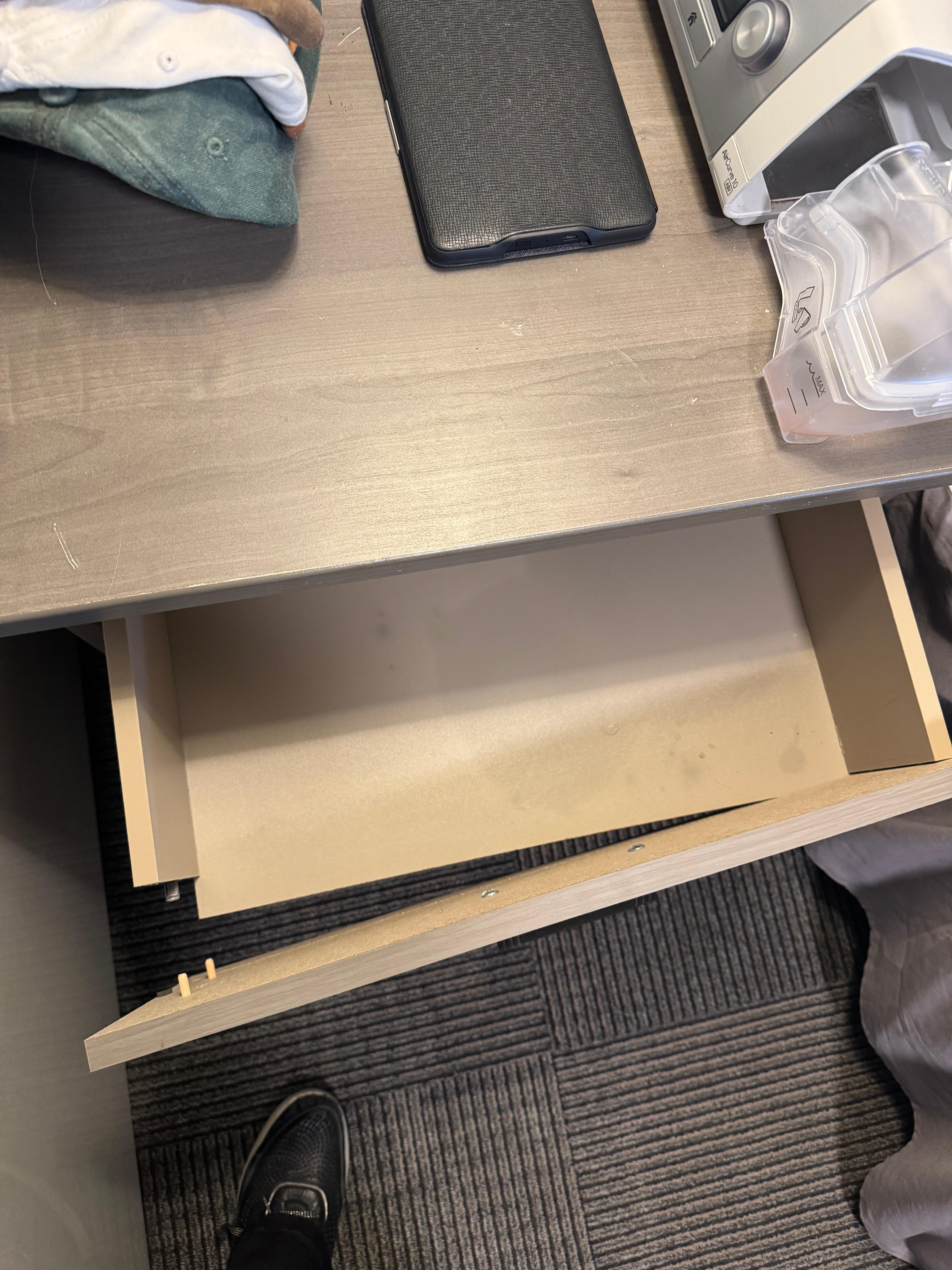 Broken drawer in bedside table.