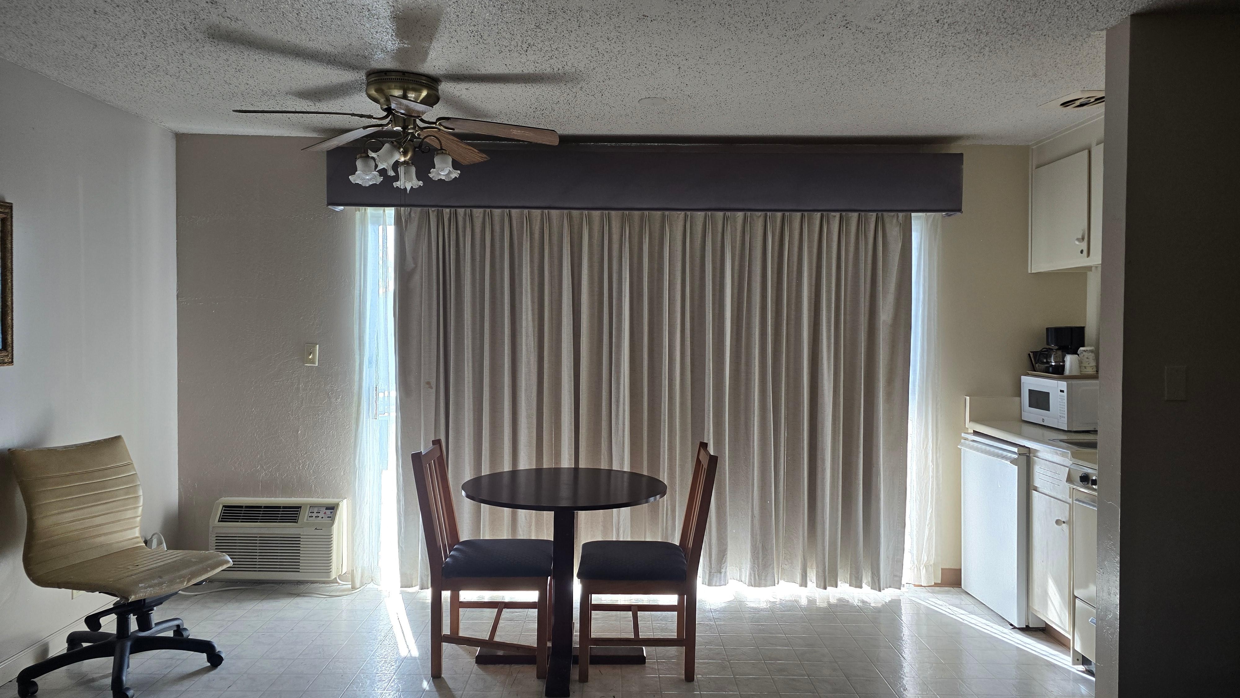 The screen door is larger than the drapery. 