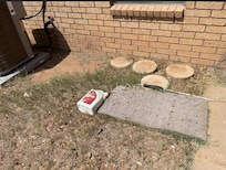 Some sort of chemical left tipped over, on the ground behind the grill
