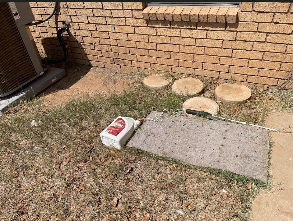 Some sort of chemical left tipped over, on the ground behind the grill