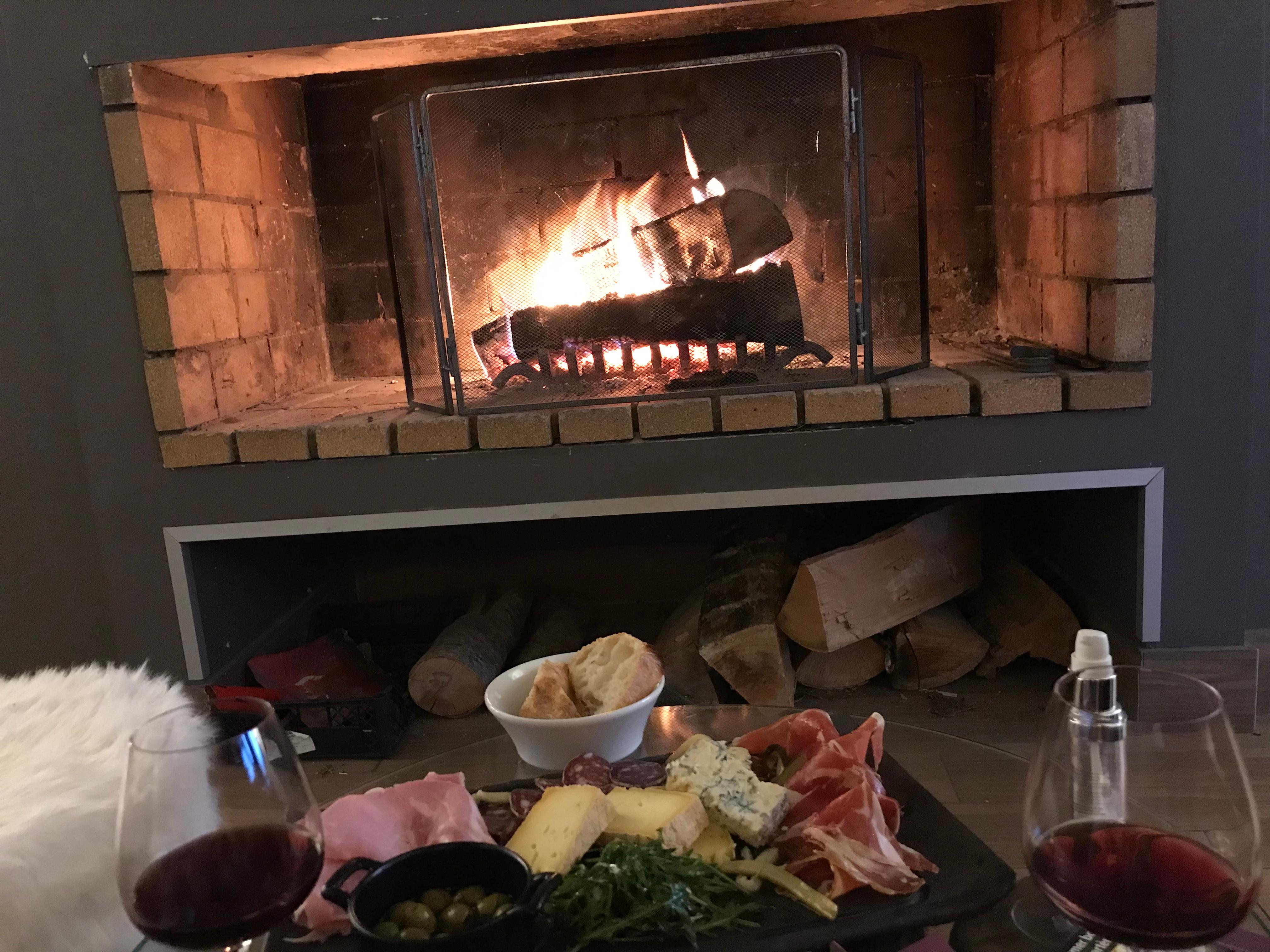 Planche de charcuterie et fromage devant un bon feu de cheminée 