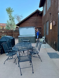 Side yard with hot tub, grill and dining area