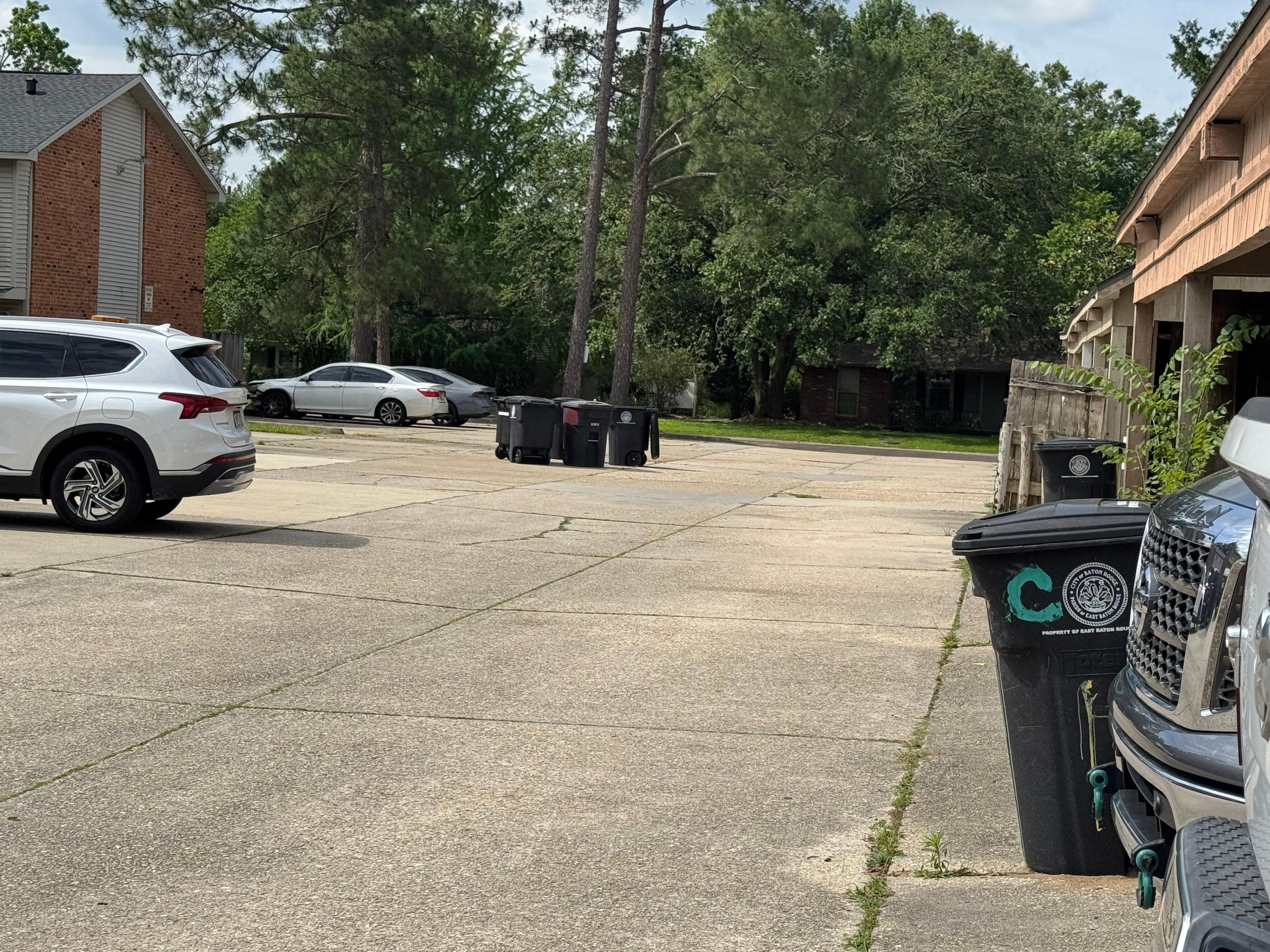 Garbage cans strewn in the parking lot. 