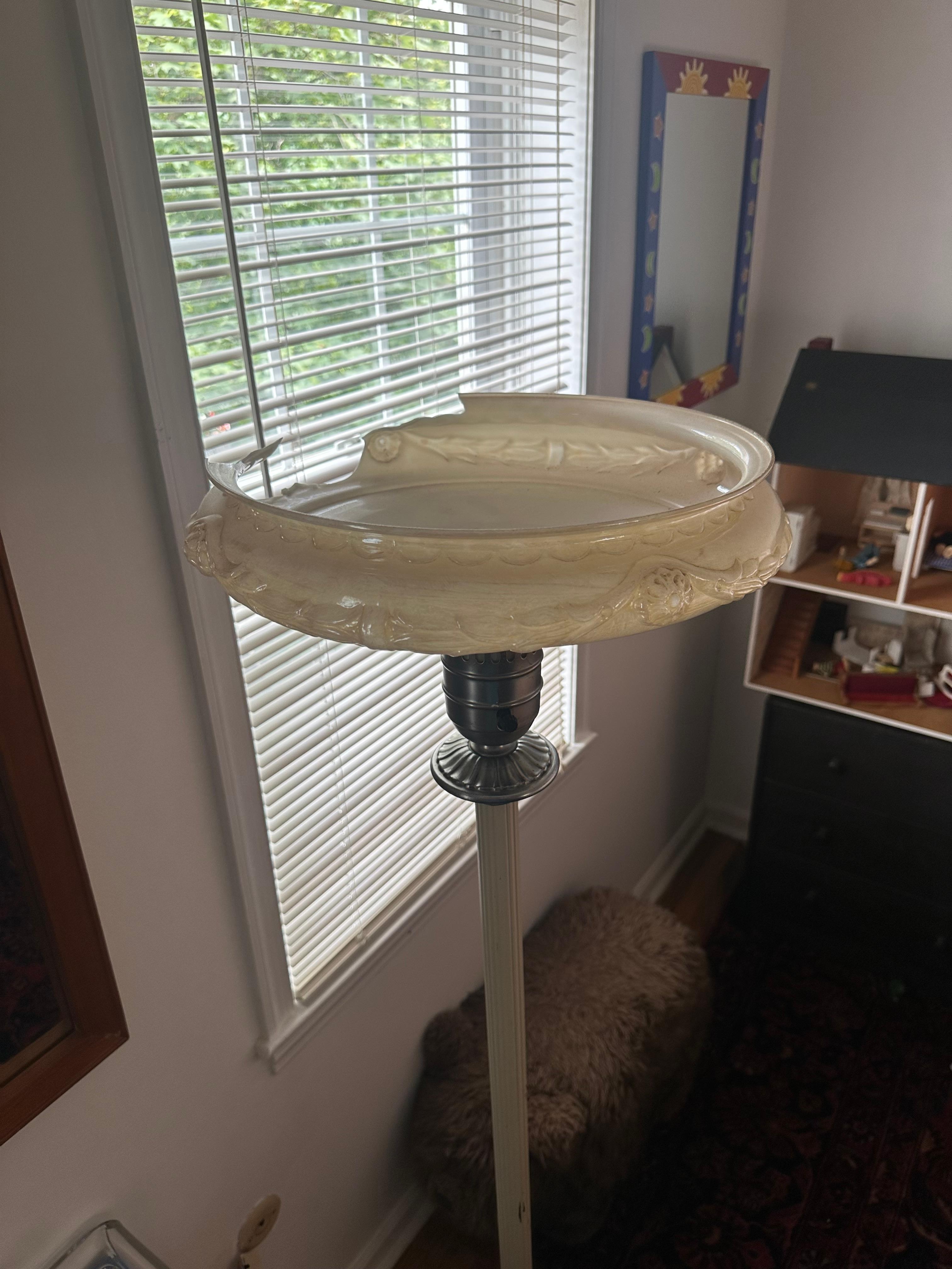 Lamp with broken shade next to dollhouse