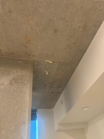 Exposed unpainted concrete in room m, tape still on roof