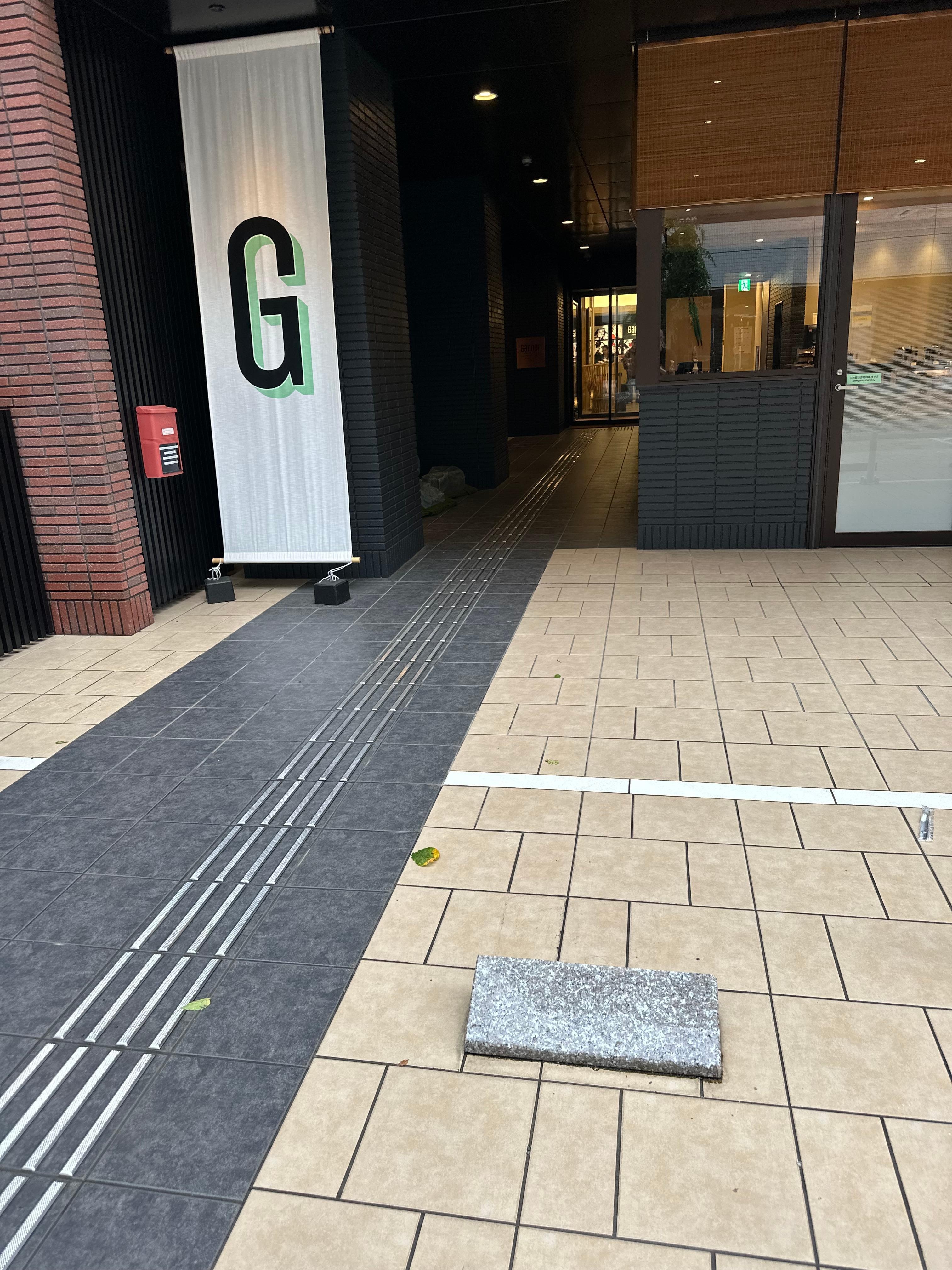 Raised parking block in front of entrance with no railing around it is a tripping hazard.
