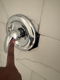 Loose shower knob showing hole in wall