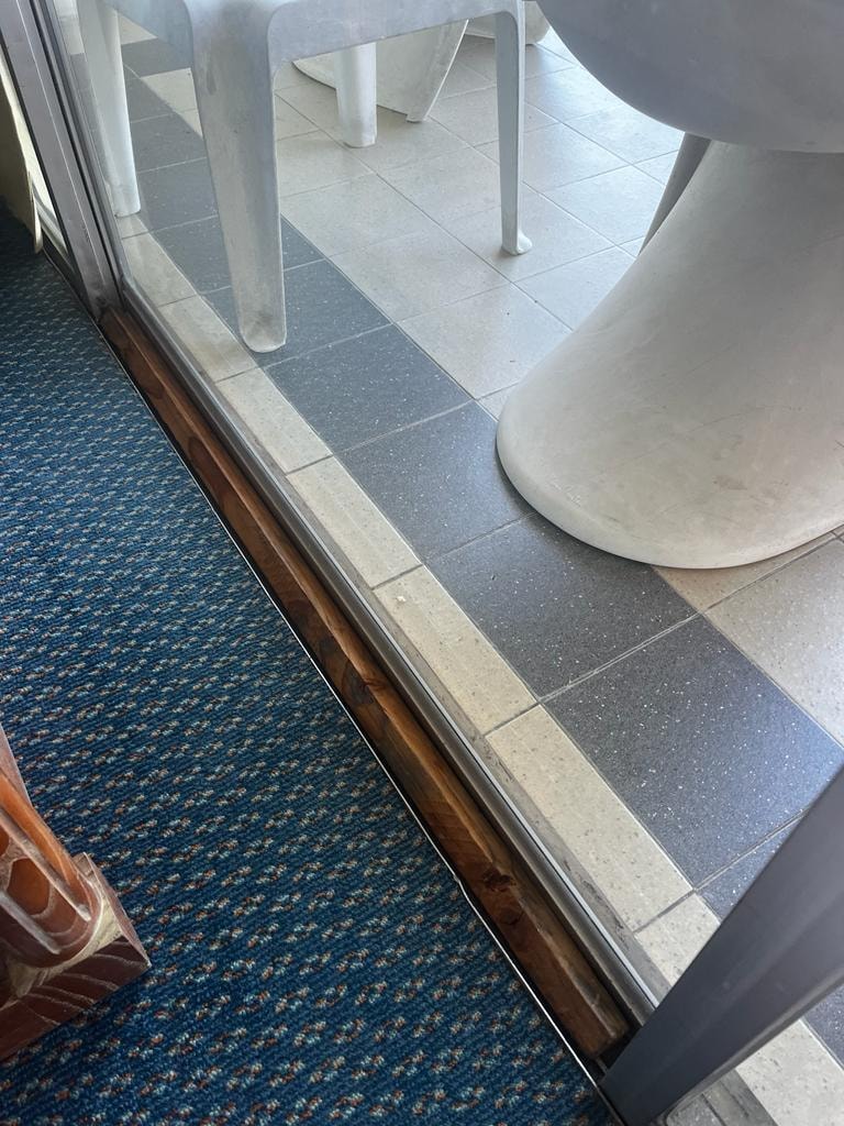 Fermeture de la baie vitrée de la chambre avec un bâton en bois