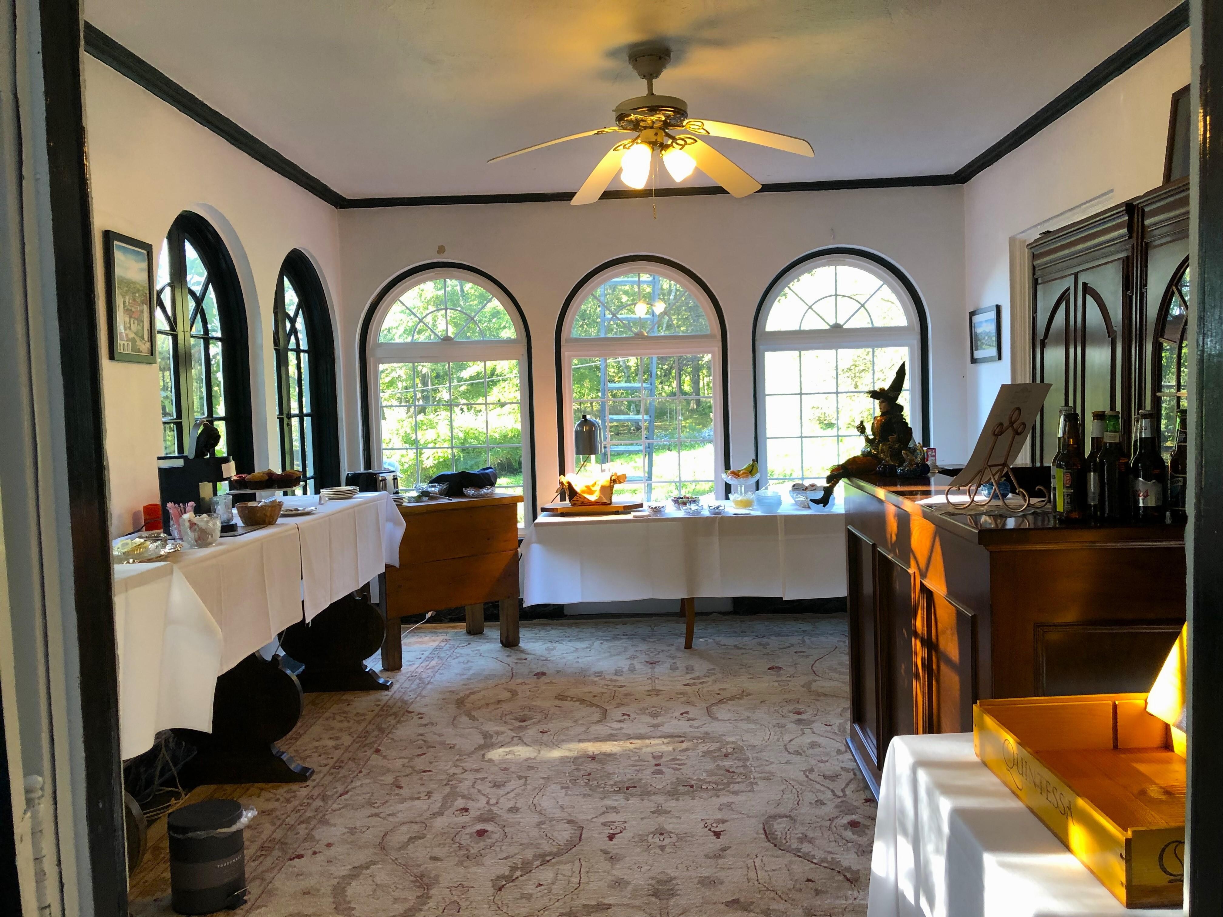 Tables full of fruits, muffins, breads, and drink variety for brkfast.