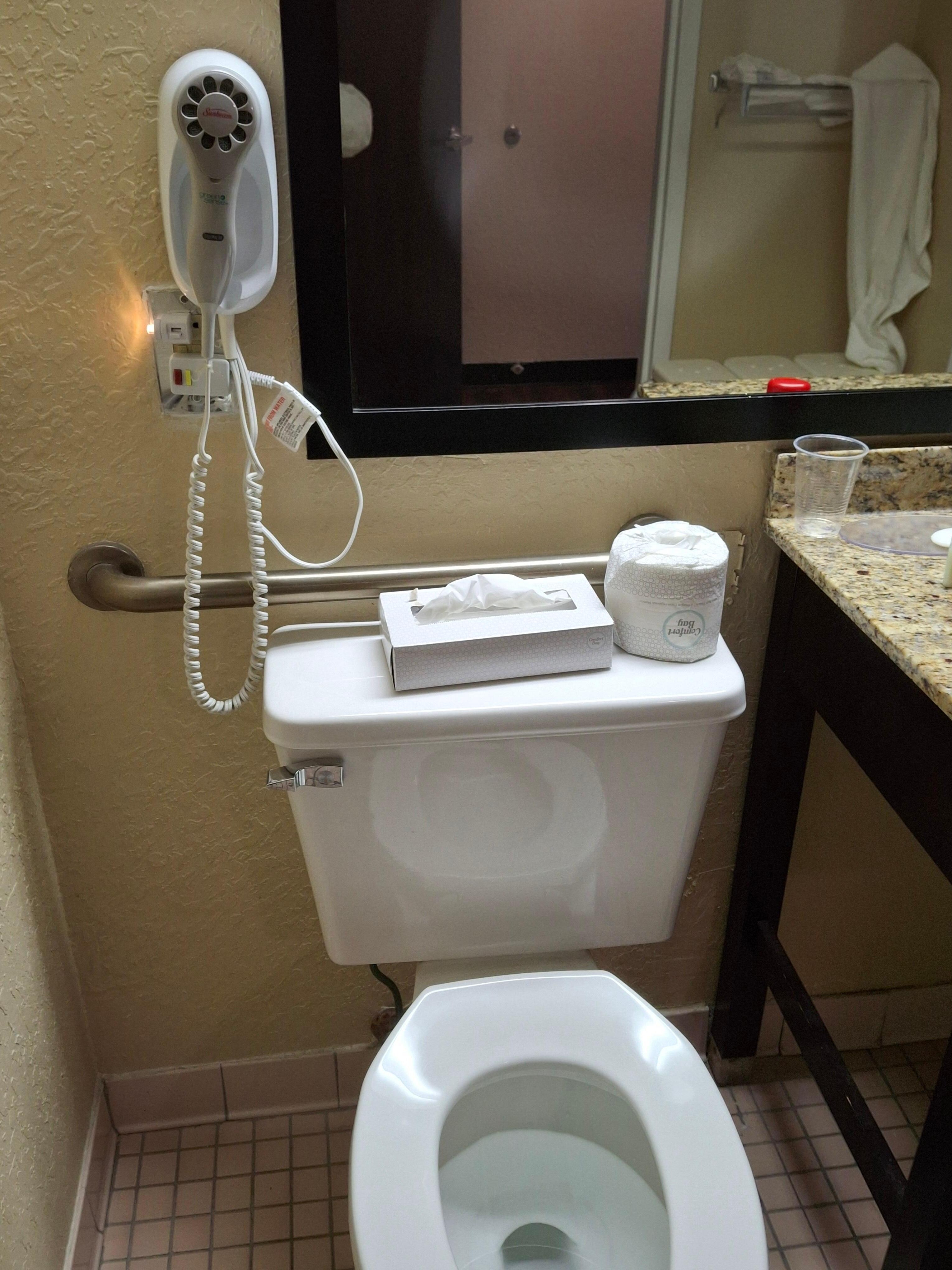 No lid on toilet. Notice the hair dryer positioned right above toilet and it was not very stable. This could have severe consequences.