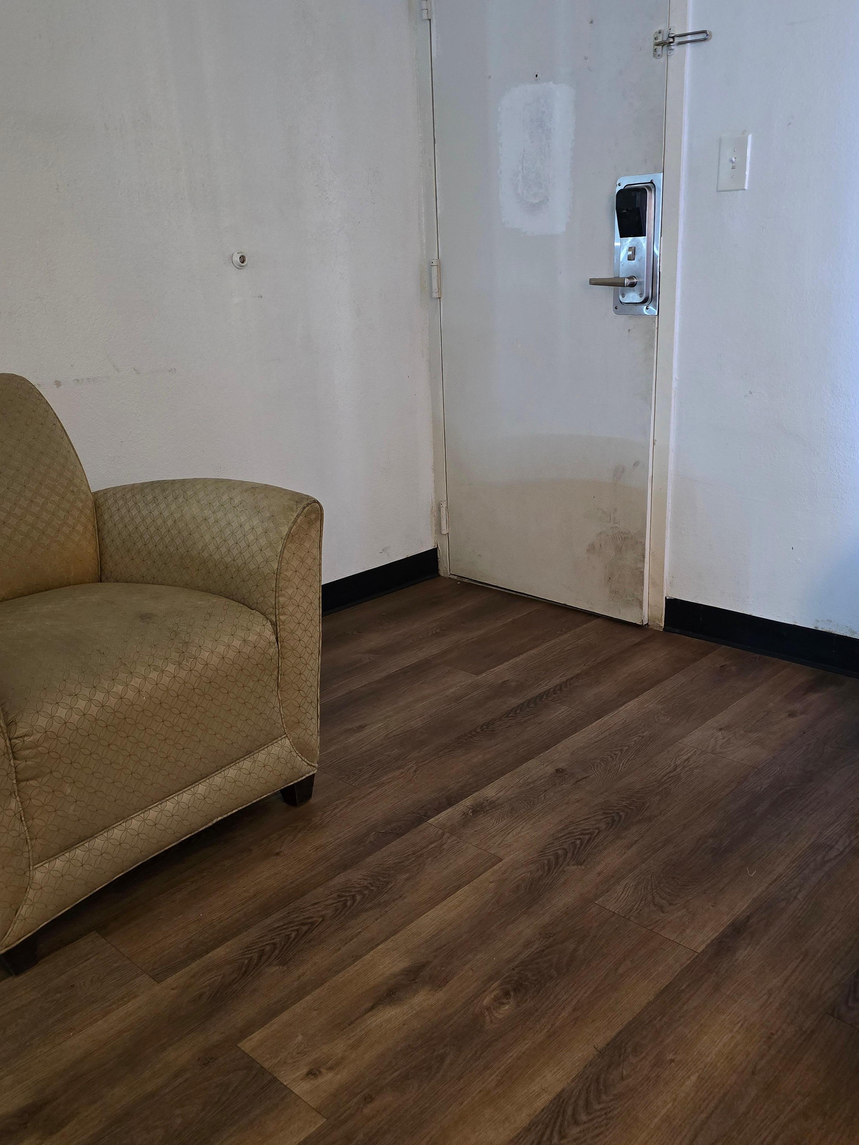 Stained chair and dirty warped door in 3rd room