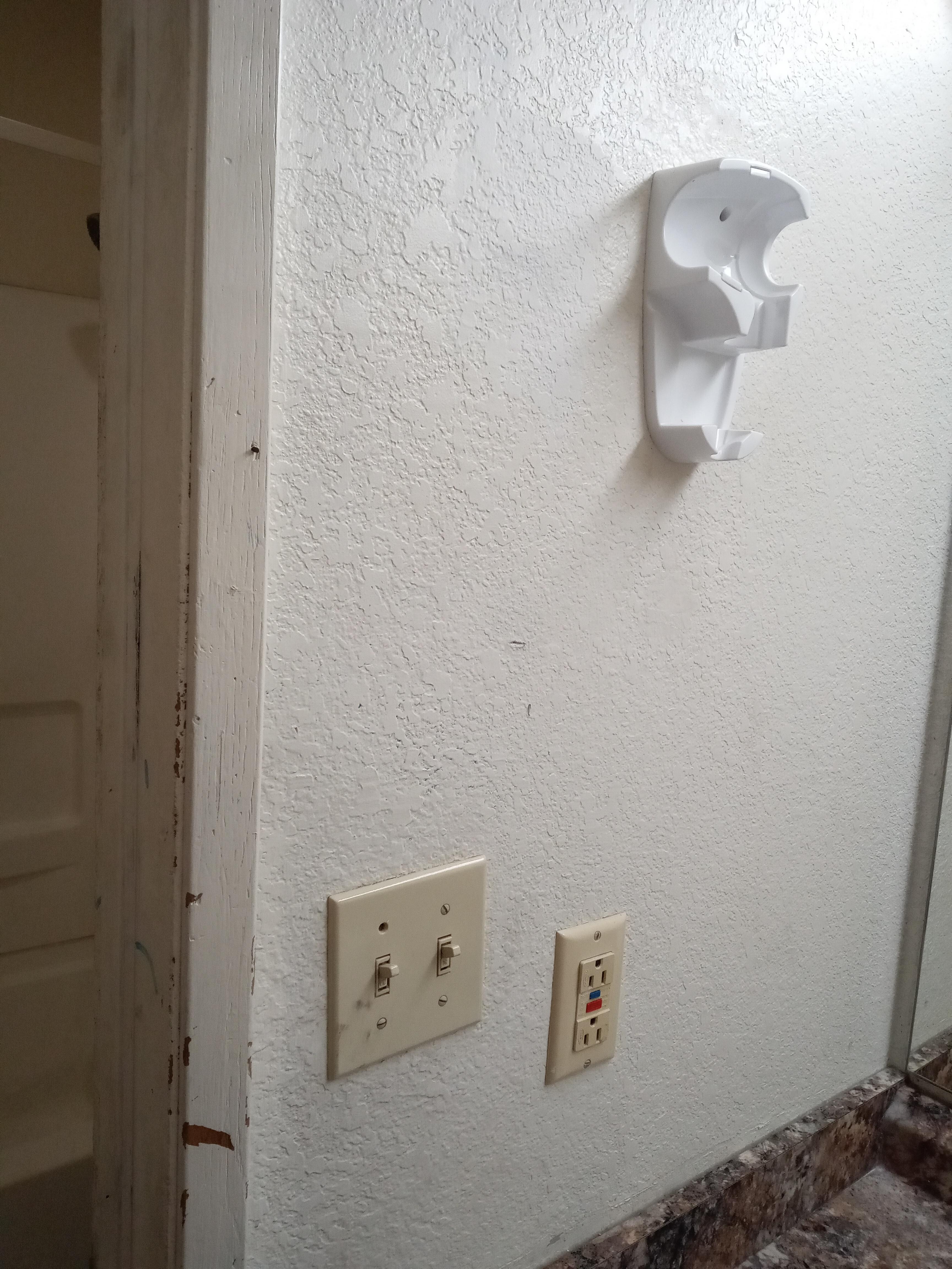 Missing hair dryer and dirty wall