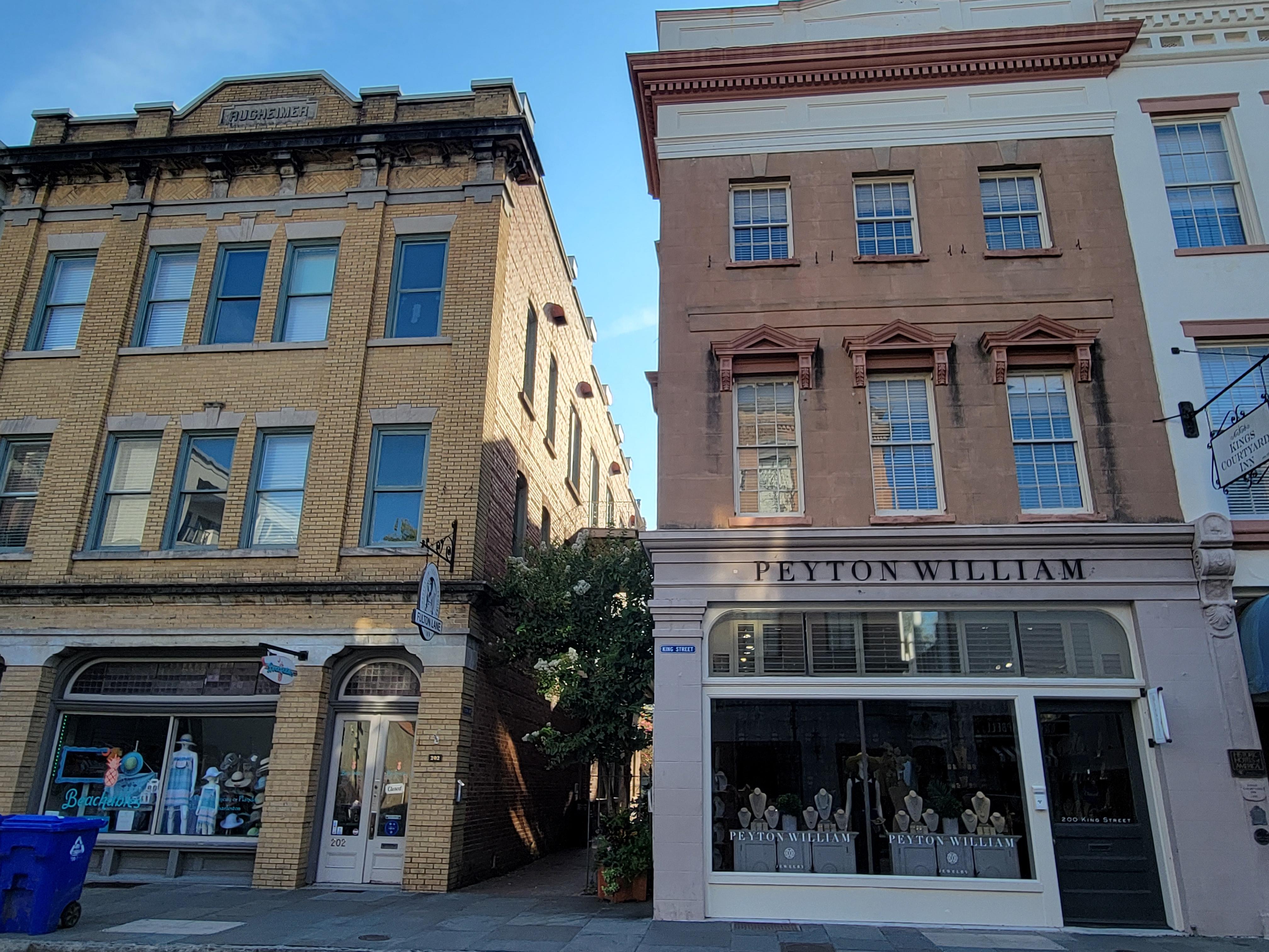 Entrance is down the alley on the side (aka Fulton Lane) between the two buildings with storefronts