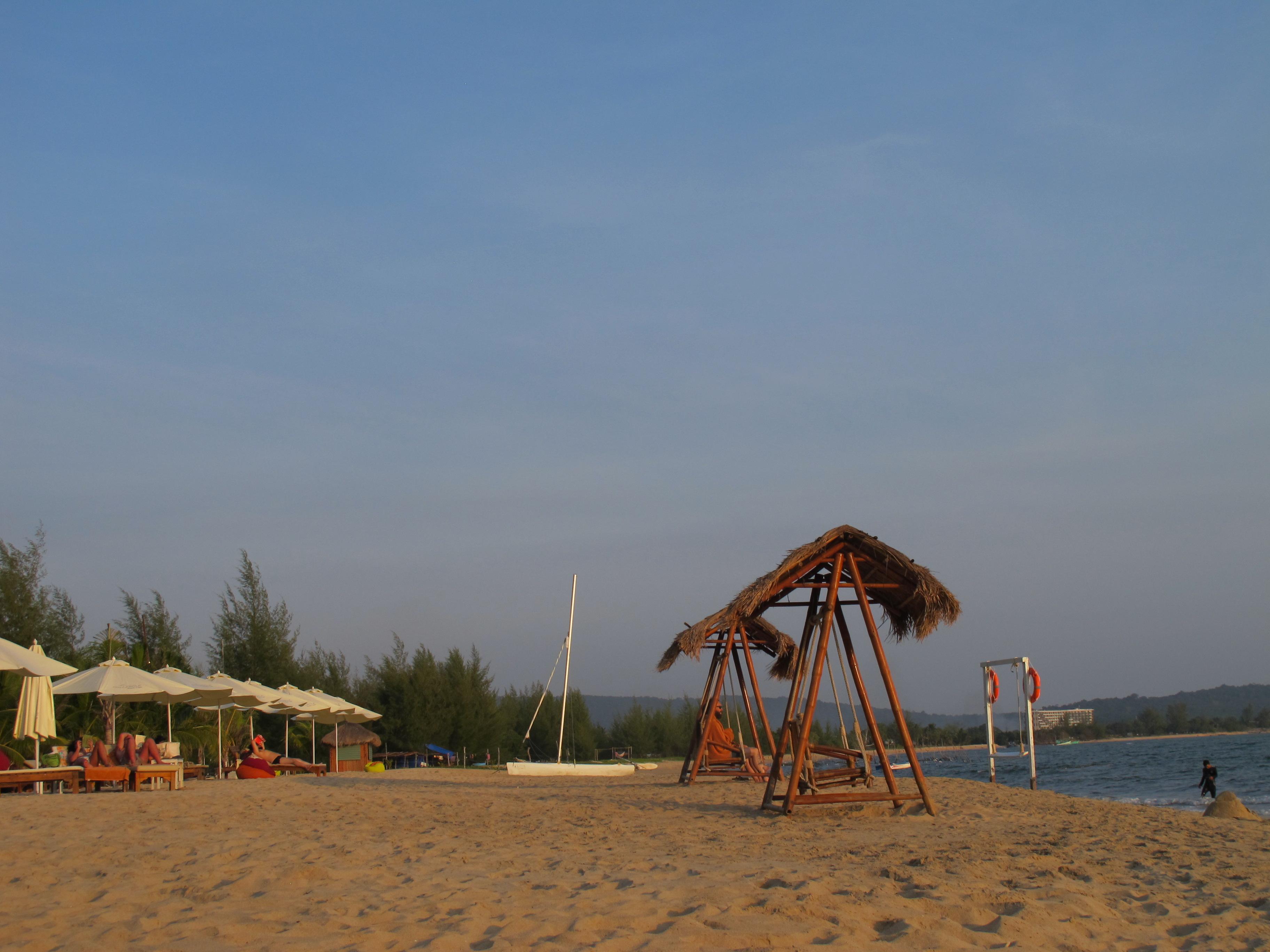 the resort's private beach area with hammocks and wooden swings as well as sun loungers