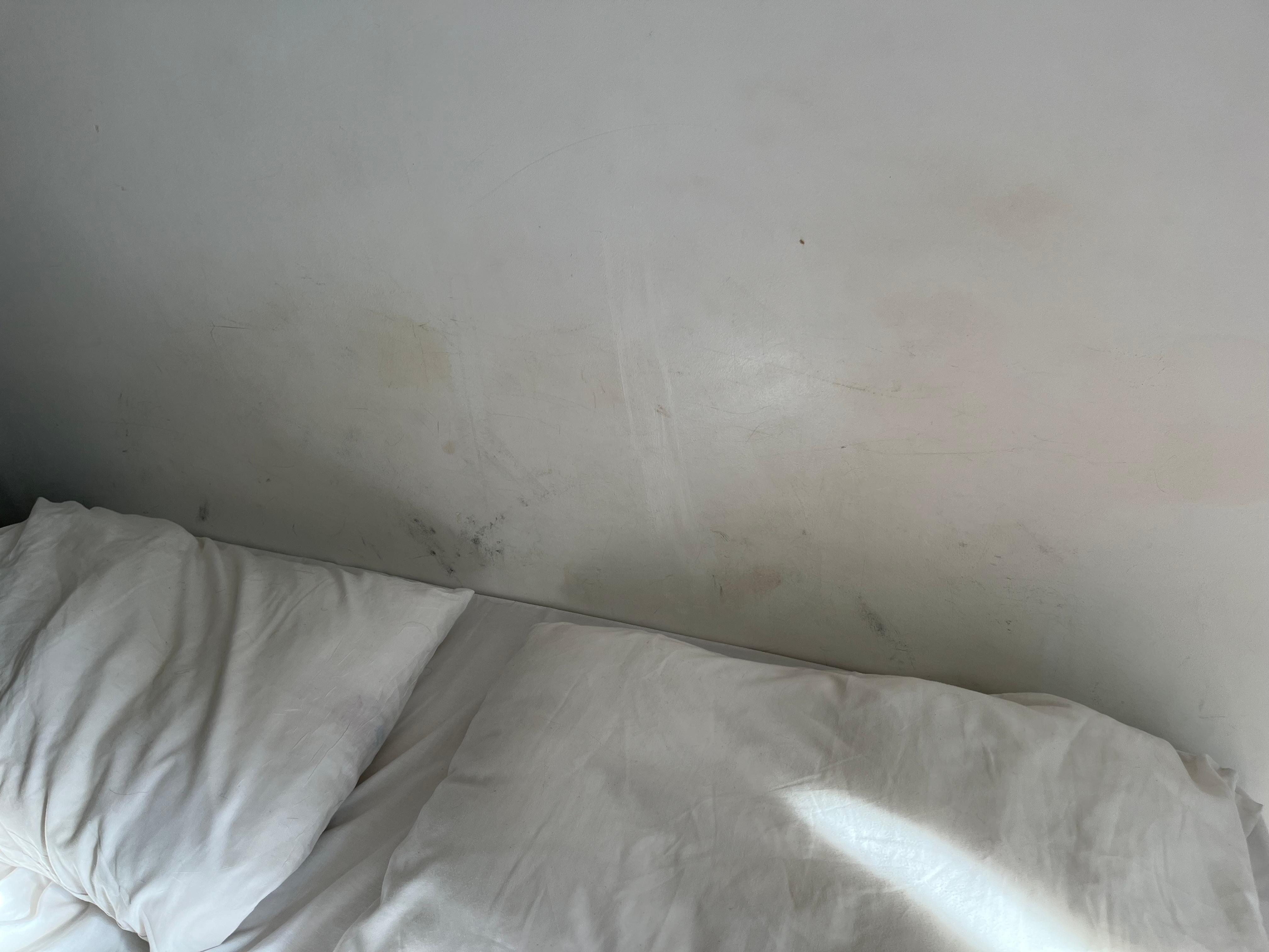 No bed headboard. Wall dirty