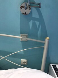 Prise électrique à la tête du lit derrière l’oreiller