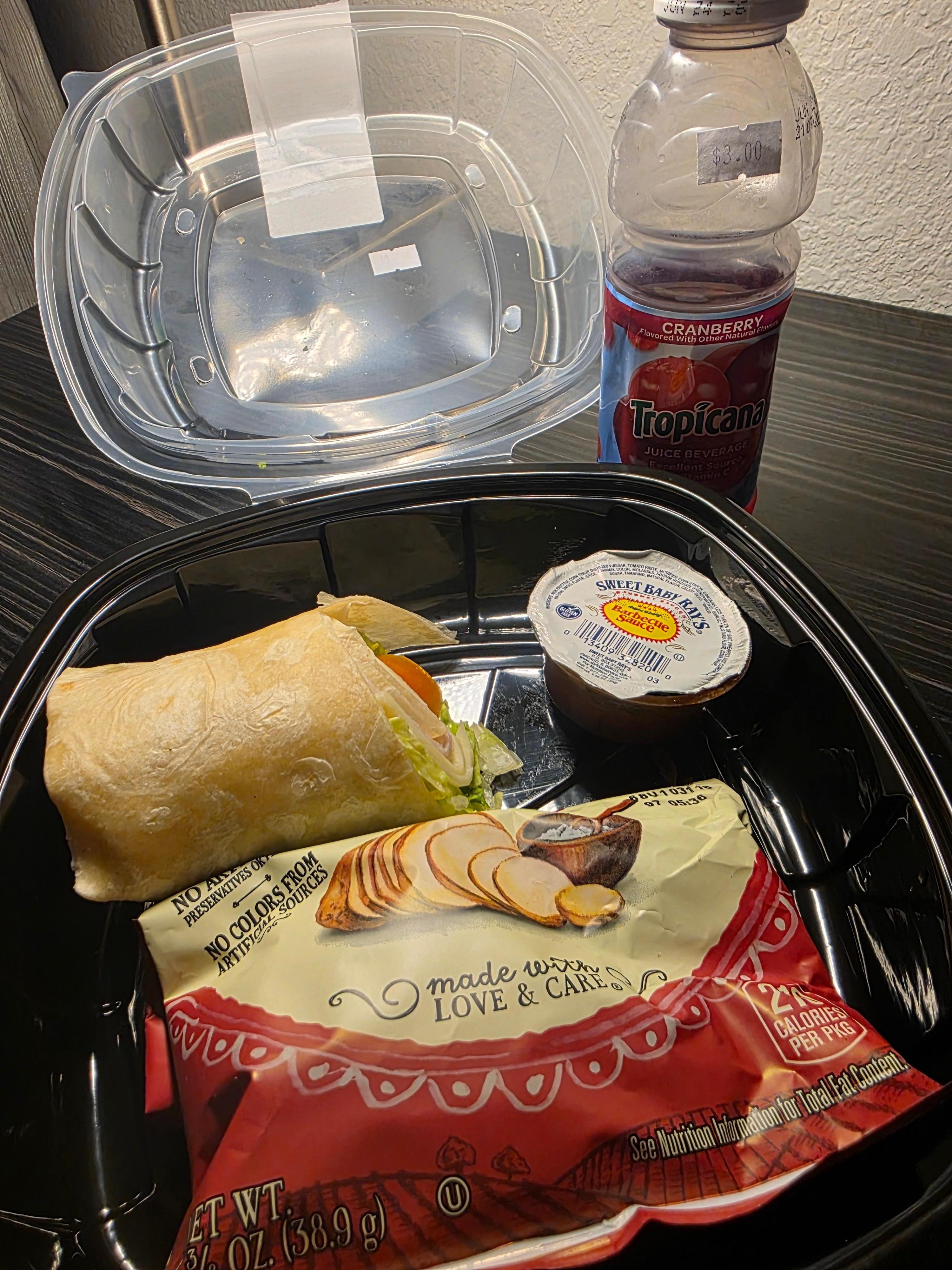 Snack/Beverage area - Half eaten Turkey, cheese wrap, sauce, and kettle chips-$10 and Cranberry Juice $3