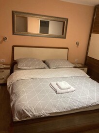 シンプルなダブルベッド。両サイドに明かりとコンセントあります