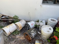 Rusted cans on side of house