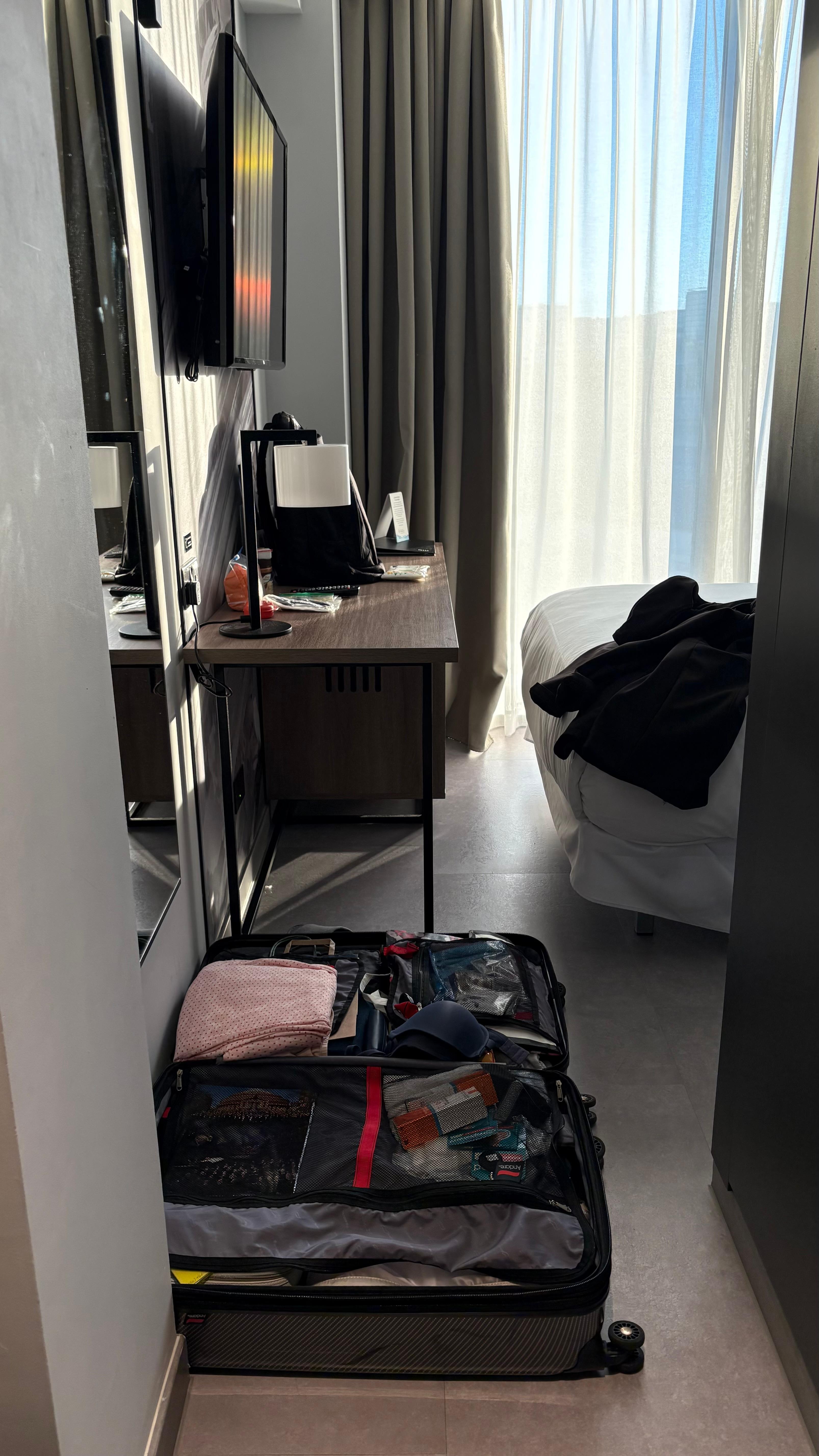 Perspective of how much space available to go to the bathroom with luggage on the floor.