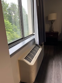 Broken lid to air conditioner behind the curtain on window ledge