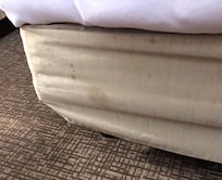 Another view of the stained and dirty covering for the base of the bed.