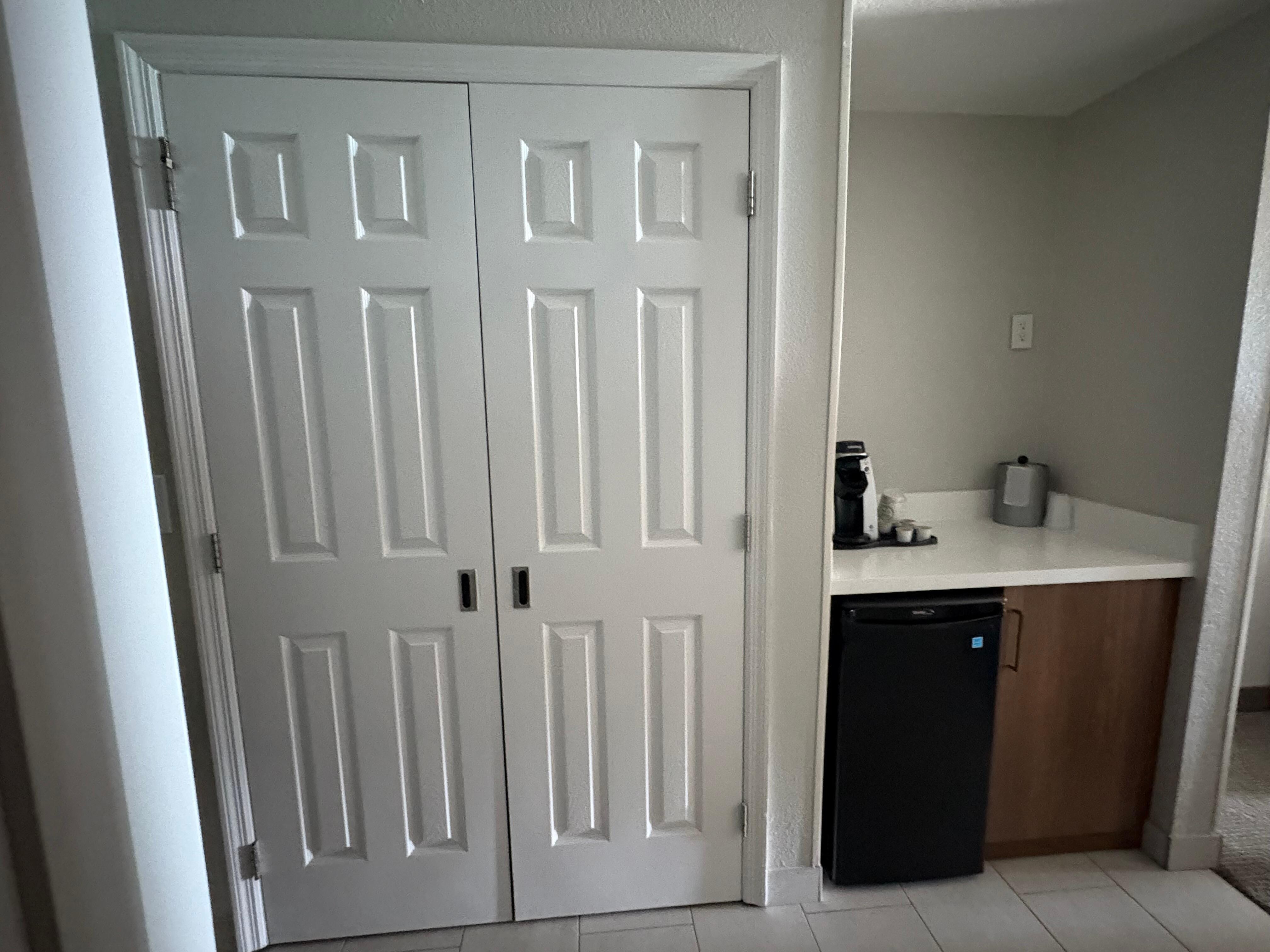 Closet with safe and area for food with refrigerator.