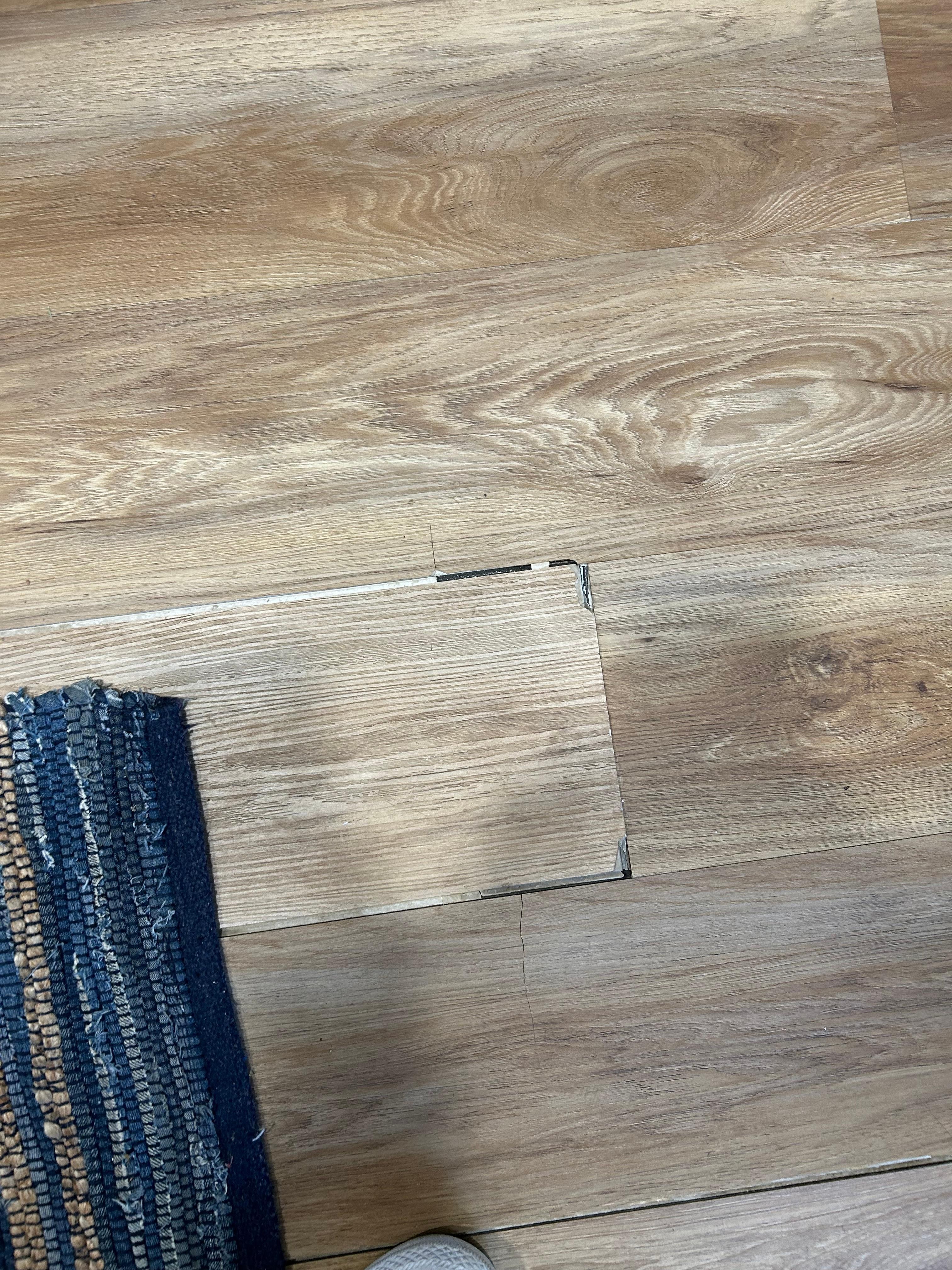 Buckled floor tried to hide with rug that slides