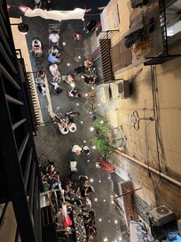 Below the balcony.