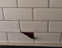 Glued on backsplash peeling off. Made place feel cheap..