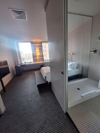 View from the door. There is a long desk in front of the window with a chair.