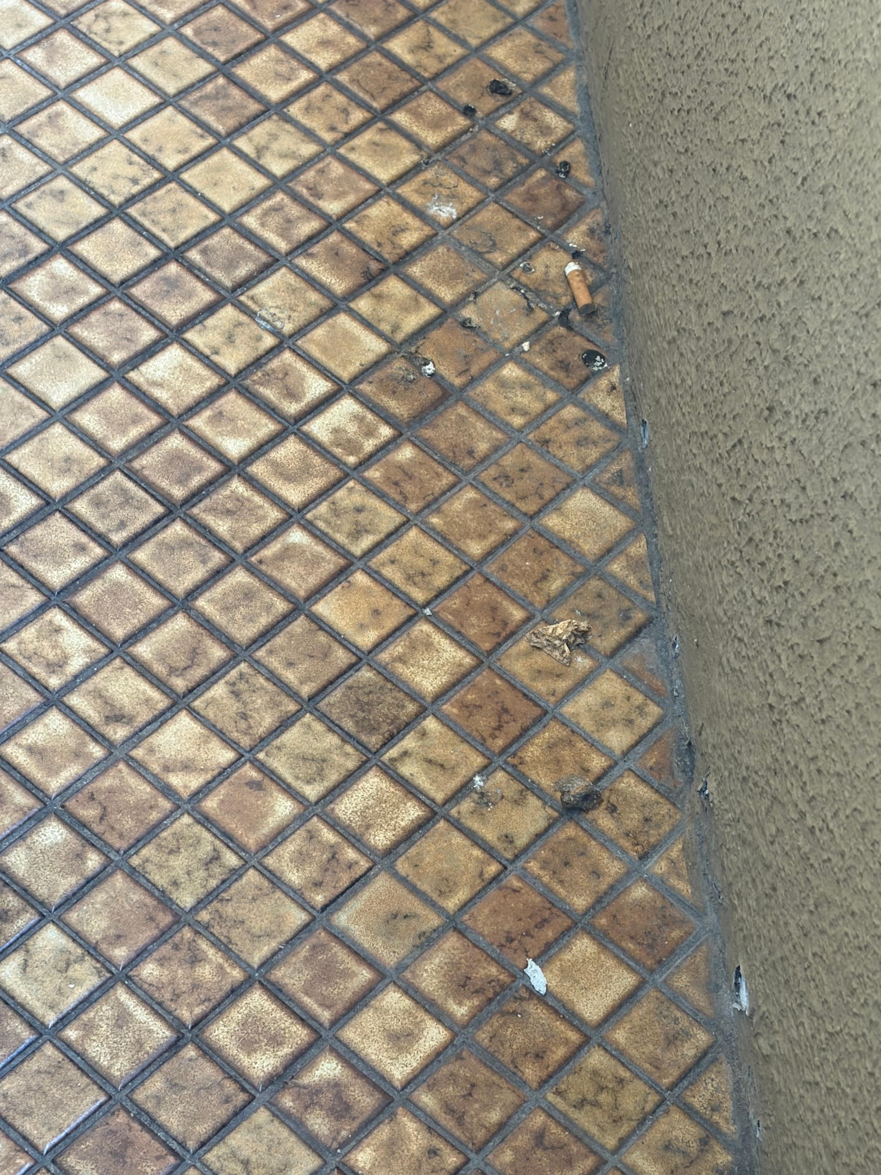 Small deck off broken sliding doors showing cigarette butts in non smoking room