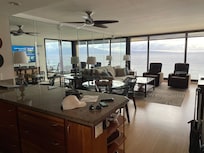 View from kitchen to living room space and thru full length windows (plus a mirrored wall behind couch)